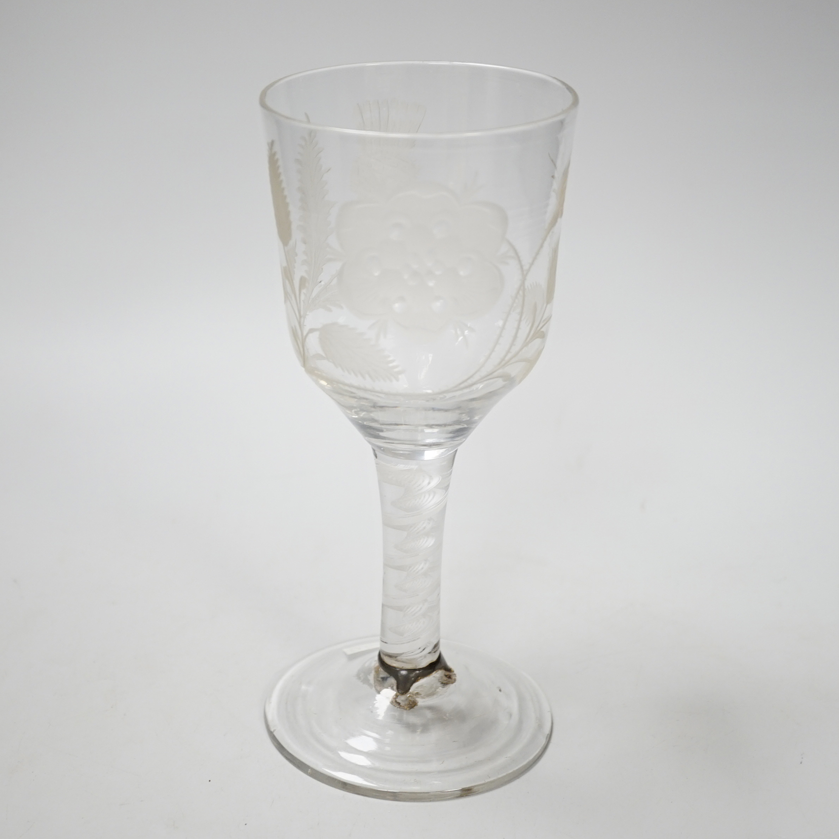 An English lead crystal Jacobite goblet, c.1750-60, bowl of ogee form, engraved with open and one closed rose and thistle, DSOT stem and plain foot with rough pontil, central gauze and multi spiral threads, tool marked,